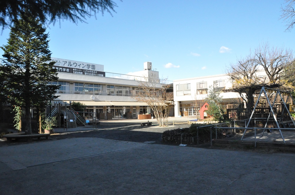 正門を入ると、園庭が広がり保育専門学校の学生と幼稚園・保育園の子どもたちが一緒に過ごしています。