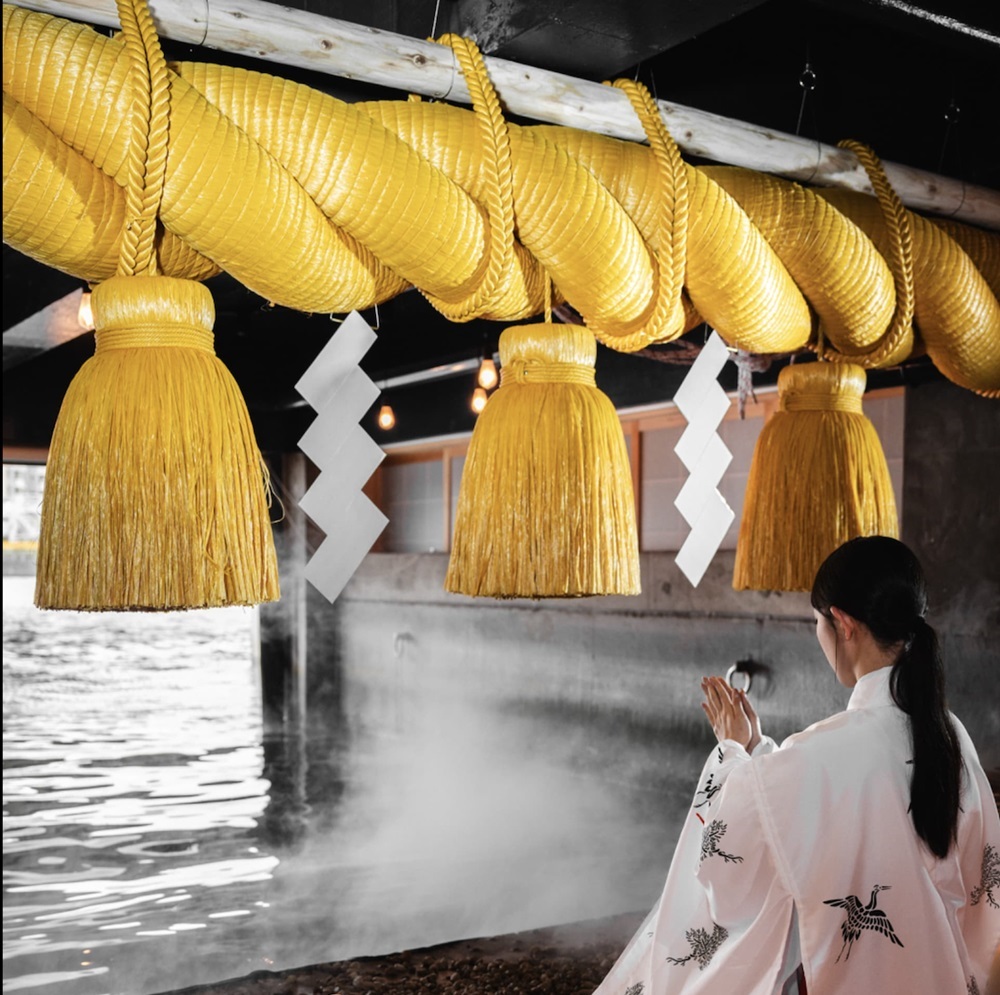 しめ縄の前でお祈り