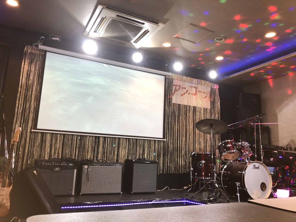 大型スクリーンのあるステージ。機材を移動し、バンド演奏や手品等のショー、演芸、カラオケ等に使えます。 大型スクリーンのあるステージ。機材を移動し、バンド演奏や手品等のショー、演芸、カラオケ等に使えます。
